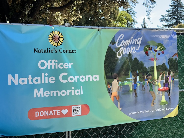 Photo of sign on the construction fence around the project site at Central Park in Davis for the new Natalie's Corner splash park in memory of Officer Natalie Corona.