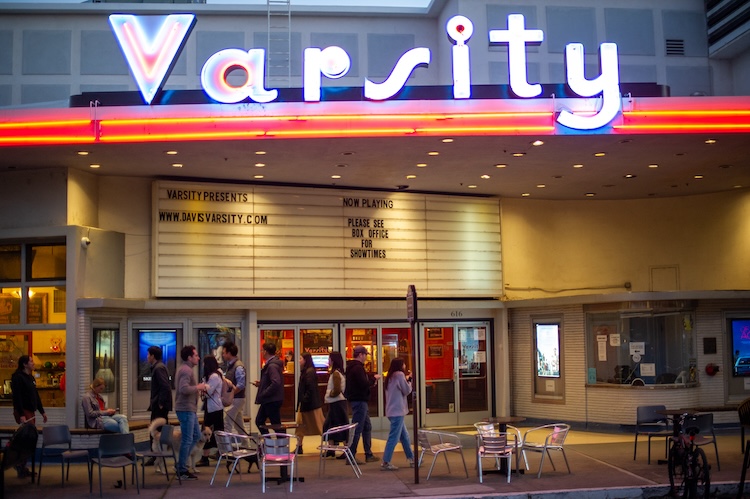 Varsity Theater in the evening with pedestrians walking by the front doors.